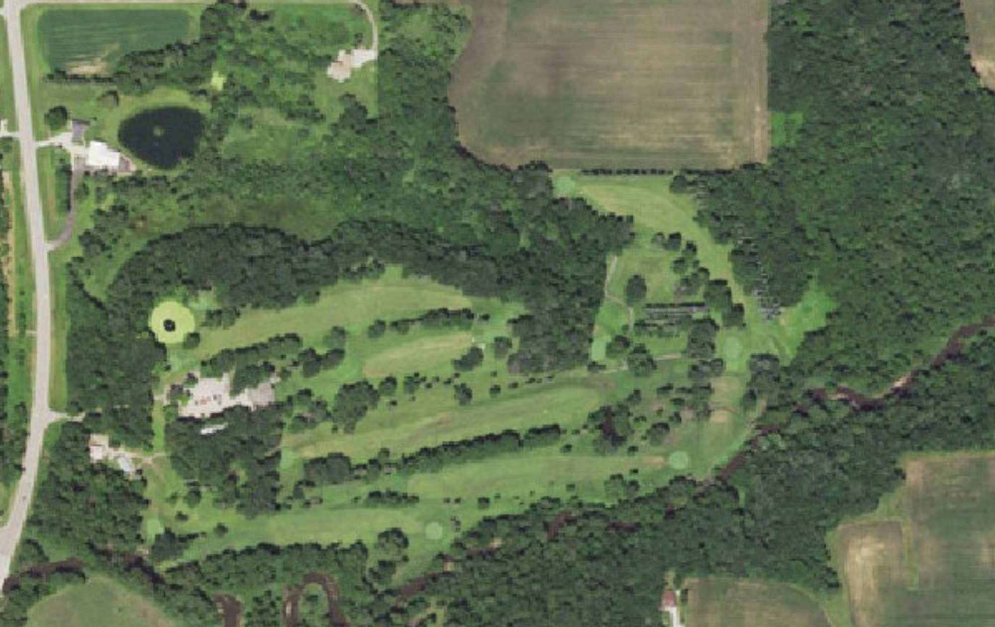 Aerial view of Kenyon Country Club: the clubhouse by Highway 56 on the left, fairways running east through the trees along the creek